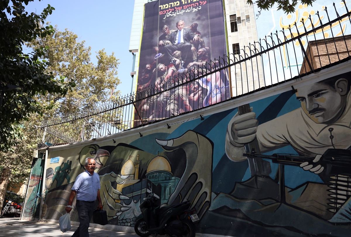 TEHRAN (IRAN(Islamic Republic Of)), 03/09/2025.- Iranians walk past a huge anti-Israeli billboard displaying a picture of Israeli Prime Minister Benjamin Netanyahu and sentences reading in Hebrew, 'Netanyahu is gambling on the lives of your children,' and in Persian, 'Mad criminal,' at the Palestine Square in Tehran, Iran, 03 September 2025. (Teherán)